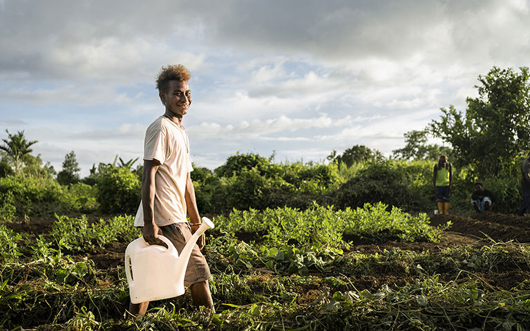 Junior 16 watering plants in a community garden in Malaita Province the Solomon Islands